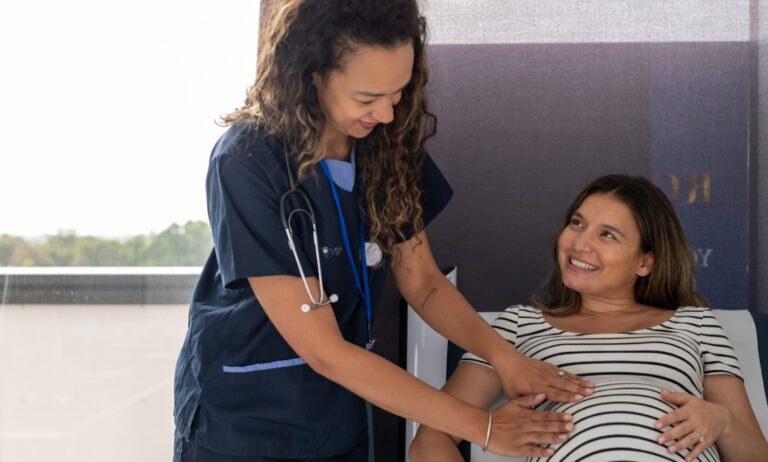a midwife feeling a pregnant woman's belly